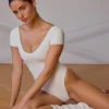 Body con pannelli e schiena scoperta in bianco tenue Body con pannelli e schiena scoperta in bianco tenue