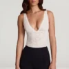 Body Zayla in pizzo trasparente con scollo a V smerlato, colore bianco Body Zayla in pizzo trasparente con scollo a V smerlato, colore bianco