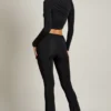 Pantaloni svasati a vita media con drappeggio asimmetrico Mairead in nero Pantaloni svasati a vita media con drappeggio asimmetrico Mairead in nero