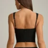Top a corsetto con cut-out e fiocco Pearla in nero Top a corsetto con cut-out e fiocco Pearla in nero