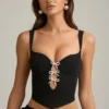 Top a corsetto con cut-out e fiocco Pearla in nero Top a corsetto con cut-out e fiocco Pearla in nero