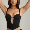 Top a corsetto con cut-out e fiocco Pearla in nero Top a corsetto con cut-out e fiocco Pearla in nero
