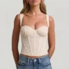Top a corsetto con ferretti in pizzo Junia, colore avorio Top a corsetto con ferretti in pizzo Junia, colore avorio