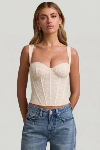 Top a corsetto con ferretti in pizzo Junia, colore avorio