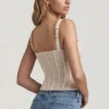 Top a corsetto con ferretti in pizzo Junia, colore avorio Top a corsetto con ferretti in pizzo Junia, colore avorio
