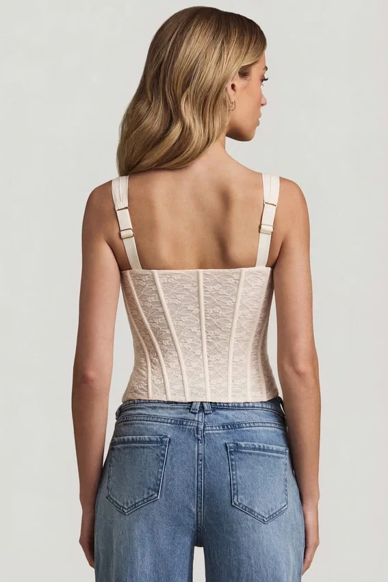 Top a corsetto con ferretti in pizzo Junia, colore avorio Top a corsetto con ferretti in pizzo Junia, colore avorio