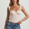 Top a corsetto con ferretti in pizzo Junia, colore avorio Top a corsetto con ferretti in pizzo Junia, colore avorio