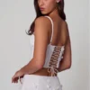 Top a corsetto con lacci e decorazioni Letitia in bianco