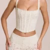 Top a corsetto con stecche e scollo rotondo in pizzo Cherith, colore avorio Top a corsetto con stecche e scollo rotondo in pizzo Cherith, colore avorio
