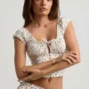Top a corsetto in popeline di cotone arricciato Faela con stampa di rose