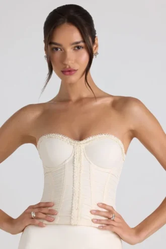 Top a corsetto senza spalline con lacci e ruches Melvina in avorio