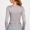 Top a maniche lunghe con scollo profondo in jersey trasparente Liah, colore grigio Top a maniche lunghe con scollo profondo in jersey trasparente Liah, colore grigio