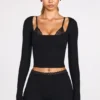 Top a reggiseno con lacci a maniche lunghe in modal a coste Margaux in nero Top a reggiseno con lacci a maniche lunghe in modal a coste Margaux in nero