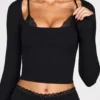 Top a reggiseno con lacci a maniche lunghe in modal a coste Margaux in nero Top a reggiseno con lacci a maniche lunghe in modal a coste Margaux in nero