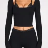 Top a reggiseno con lacci a maniche lunghe in modal a coste Margaux in nero Top a reggiseno con lacci a maniche lunghe in modal a coste Margaux in nero