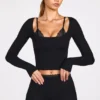 Top a reggiseno con lacci a maniche lunghe in modal a coste Margaux in nero Top a reggiseno con lacci a maniche lunghe in modal a coste Margaux in nero