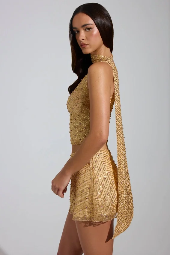 Top asimmetrico con dettagli a sciarpa decorato Cosette in oro Top asimmetrico con dettagli a sciarpa decorato Cosette in oro