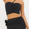 Top asimmetrico in jersey elasticizzato con dettagli a rosa di Tesia in nero Top asimmetrico in jersey elasticizzato con dettagli a rosa di Tesia in nero
