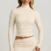 Top Auri in Modal con collo alto, ruches e schiena scoperta, colore avorio Top Auri in Modal con collo alto, ruches e schiena scoperta, colore avorio