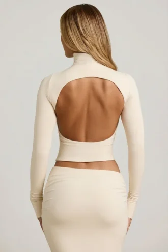 Top Auri in Modal con collo alto, ruches e schiena scoperta, colore avorio