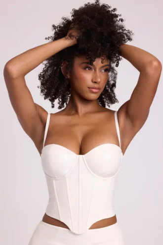 Top corto a corsetto con ferretti in vinile Cassandra, bianco
