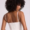 Top corto a corsetto con ferretti in vinile Cassandra, bianco Top corto a corsetto con ferretti in vinile Cassandra, bianco
