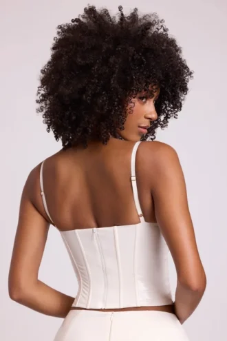 Top corto a corsetto con ferretti in vinile Cassandra, bianco
