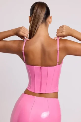 Top corto a corsetto con ferretti in vinile Cassandra, rosa