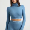 Top corto a maniche lunghe con collo alto e schiena scoperta in blu acciaio Top corto a maniche lunghe con collo alto e schiena scoperta in blu acciaio