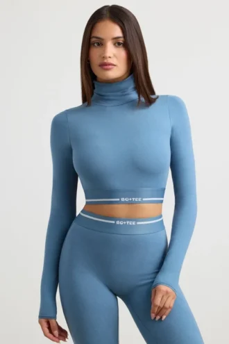 Top corto a maniche lunghe con collo alto e schiena scoperta in blu acciaio