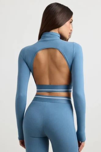 Top corto a maniche lunghe con collo alto e schiena scoperta in blu acciaio