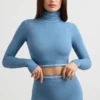 Top corto a maniche lunghe con collo alto e schiena scoperta in blu acciaio Top corto a maniche lunghe con collo alto e schiena scoperta in blu acciaio
