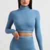 Top corto a maniche lunghe con collo alto e schiena scoperta in blu acciaio Top corto a maniche lunghe con collo alto e schiena scoperta in blu acciaio