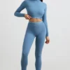 Top corto a maniche lunghe con collo alto e schiena scoperta in blu acciaio Top corto a maniche lunghe con collo alto e schiena scoperta in blu acciaio