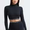 Top corto a maniche lunghe con collo alto e schiena scoperta in nero Top corto a maniche lunghe con collo alto e schiena scoperta in nero