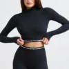 Top corto a maniche lunghe con collo alto e schiena scoperta in nero Top corto a maniche lunghe con collo alto e schiena scoperta in nero