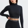 Top corto a maniche lunghe con collo alto e schiena scoperta in nero Top corto a maniche lunghe con collo alto e schiena scoperta in nero