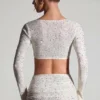 Top corto a maniche lunghe con decorazioni Lumina in bianco Top corto a maniche lunghe con decorazioni Lumina in bianco