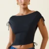 Top corto asimmetrico con scollo a cappuccio e ruches Kaede in nero Top corto asimmetrico con scollo a cappuccio e ruches Kaede in nero