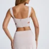 Top corto con cut-out e dettagli metallici Kira in grigio cielo Top corto con cut-out e dettagli metallici Kira in grigio cielo