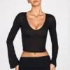 Top Liah in jersey trasparente con scollo profondo e maniche lunghe, colore nero Top Liah in jersey trasparente con scollo profondo e maniche lunghe, colore nero