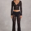 Top Lioren in pizzo trasparente con scollo profondo e maniche lunghe, colore nero Top Lioren in pizzo trasparente con scollo profondo e maniche lunghe, colore nero