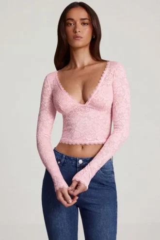 Top Lioren in pizzo trasparente con scollo profondo e maniche lunghe, colore rosa