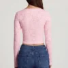 Top Lioren in pizzo trasparente con scollo profondo e maniche lunghe, colore rosa Top Lioren in pizzo trasparente con scollo profondo e maniche lunghe, colore rosa