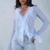 Top trasparente con bordi in piume Elisia in blu tenue Top trasparente con bordi in piume Elisia in blu tenue