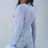 Top trasparente con bordi in piume Elisia in blu tenue Top trasparente con bordi in piume Elisia in blu tenue