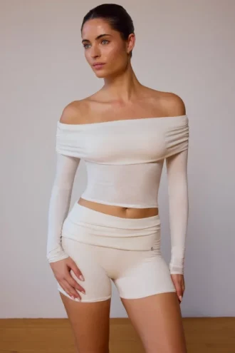 Top trasparente con spalle scoperte e maniche lunghe in bianco tenue