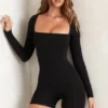 Tuta a maniche lunghe con scollo quadrato Rue in nero Tuta a maniche lunghe con scollo quadrato Rue in nero