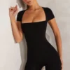 Tuta Bea con maniche ad aletta e scollo quadrato in nero Tuta Bea con maniche ad aletta e scollo quadrato in nero