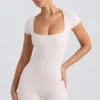 Tuta con scollo rotondo in crema slavata Tuta con scollo rotondo in crema slavata